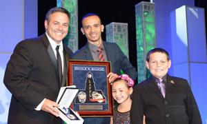 Gabriel Maldonado (second from left), who served on the founding board of Harbor Area’s Teen-Community Police Advisory Board, presents Councilmember Joe Buscaino with the “In the Line of Duty” award. Buscaino’s children joined him on the stage.